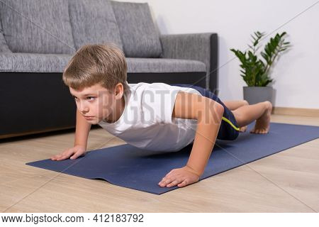 Boy On Yoga Mat At Home Holding Plank Pose. Child Physical Activity On Quarantine Healhty Lifestyle 
