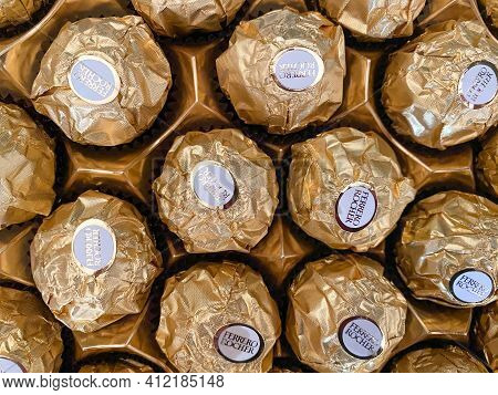 Grodno, Belarus - 03.09.2021: Background Of Golden Ferrero Rocher Candies Close-up. Texture Of Ferre
