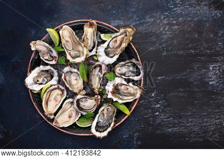 Fresh Oysters With Lime On A Round Plate. Oyster Season. Seafood Dish On A Blue Background. Oyster O