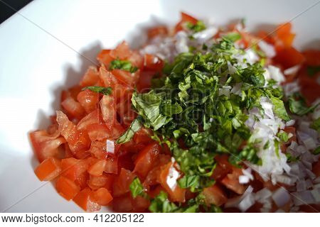 Preparation For Bruscetta Make The Ingredients For The Topping In A White Bowl.