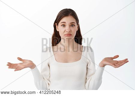 Confused Young Woman Spread Palms Aside And Shrugging Shoulders, Know Nothing, Cant Decide, Have No 