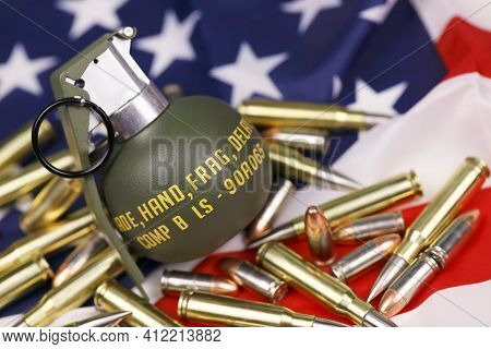 M67 Frag Grenade And Many Yellow Bullets And Cartridges On United States Flag. Concept Of Gun Traffi