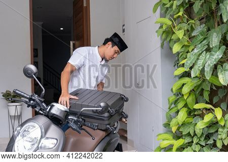 Male Muslim Pack His Suitcase On His Motorbike Getting Ready To Travel During Eid Mubarak