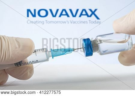 A Vaccination Syringe And A Glass Ampoule With A Clear Liquid On A Blue Background With The Logo Of 