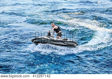 Kherson, Ukraine - July 22, 2020: A Young Man Cuts The Waves On A Jet Ski In The Dnieper River In Kh