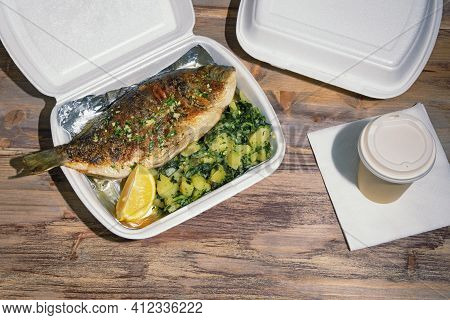 Food Delivery. Grilled Fish ( Sea Bream ) With Green Leafy Vegetables And Slice Of Lemon In Takeout 