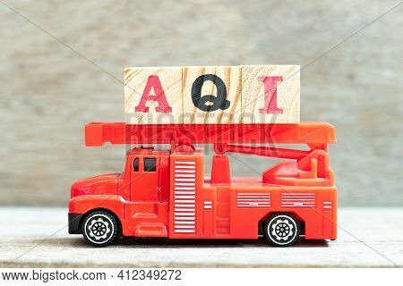 Fire Ladder Truck Hold Letter Block In Word Aqi (abbreviation Of Air Quality Index)  On Wood Backgro