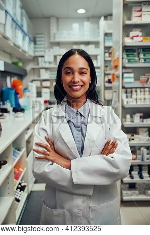 Portrait Of Smiling Young African American Woman Pharmacist Wearing Labcoat Standing In Chemist