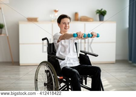 Physical Rehabilitation For Disabled People. Handicapped Teenager In Wheelchair Making Exerises With