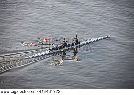 Prague, Czech Republic - February 24, 2021. Two Young Active People Rowing In Moldau River