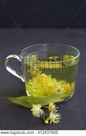 Cup Of Tea.linden Flowers Tea.cup Of Hot Herbal Tea With Linden Fresh Flowers On A Black Table.healt