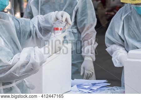 Outdoor Health Workers Group In Ppe Suits Are Collecting Sputum And Saliva Samples To Detect Infecti