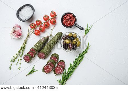 Traditianal Fuet Sausage In Herbs With Ingredients On White Textured Background.