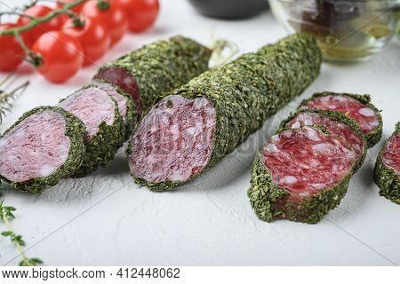 Traditianal Fuet Sausage In Herbs With Ingredients On White Textured Background.