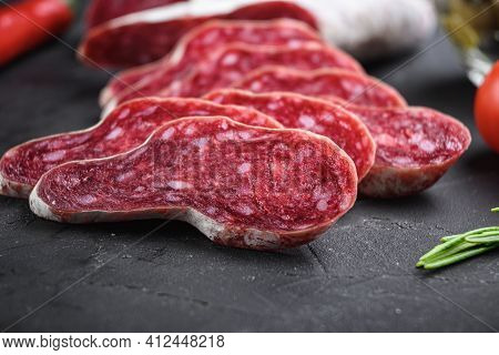Spanish Longaniza Salami Sausage Slices With Herbs On Balck Background.