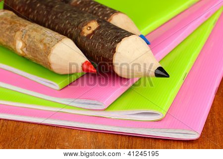 Kolorowe kredki drewniane z exercisebooks na drewnianym stole