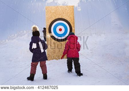 Two Girls Throw Snowballs At A Target In Winter On A Sunny Day, Outdoor Fun Games, Kids Competition