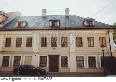 Przemysl, Poland - October, 2016: Beige House With Brown Windows, Old Wooden Door, Grey Roof With Sm