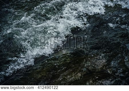 Nature Background Of Dark Water Stream Of Mountain River With Rapids. Full Frame Of Sea Surf. Natura