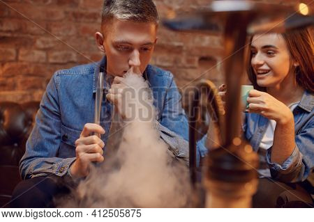 Young love couple relax in hookah bar, hooka smoke