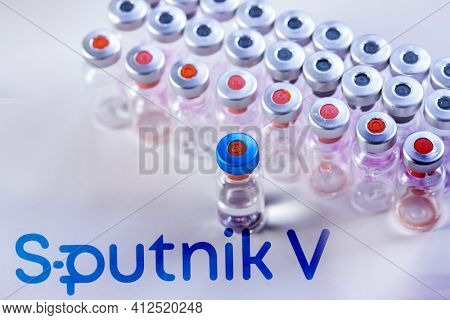 CLUJ-NAPOCA -ROMANIA - MARCH 9 2021: Sputnik Vaccine Covid-19 concept. Syringe needle and vaccine, blurred Sputnik V company logo on the background.