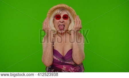 Funny Silly Senior Woman Tourist In Swimsuit, Fooling Around Making Stupid Brainless Expression