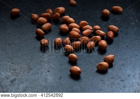 Stock Photo Of Brown Color Raw Peanuts Kept On Black Granite Stone Under Natural Light In Kitchen. F