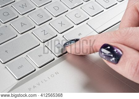 Sankt-petersburg, Russia, March 9, 2021: Laptop User Finger Pressing Windows Icon Key Button On Micr