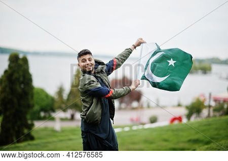 Сonfident Pakistani Indian Muslim Arabic Boy In Grey Kameez Shalwar Suit With Pakistan Flag.