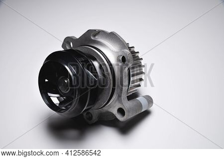 Close-up Of A New Internal Combustion Engine Cooling Water Pump On A Gray Background. Contrast Light
