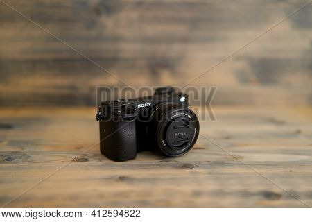 Budva, Montenegro - 15 March 2021: Sony A6300 Camera With 16-50mm Lens On Wooden Background Texture.