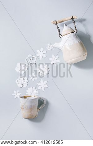 Creative Layout With White Paper Flowers Over Gray