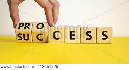 Success Process Symbol. Businessman Turns Wooden Cubes And Changes The Word 'success' To 'process'.