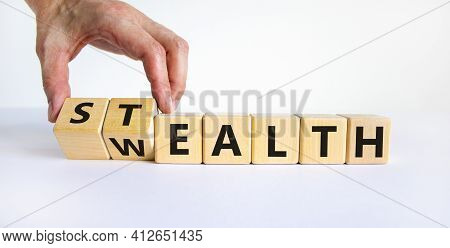 Stealth Wealth Symbol. Businessman Turns Wooden Cubes And Changes The Word 'wealth' To 'stealth'. Be