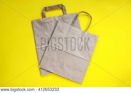 Recycled Brown Paper Shopping Bag With Handle, Isolated On Yellow Background, Flat Lay, Mockup. Two 