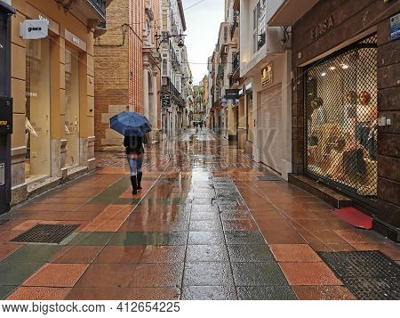 Málaga, Spain - February 21, 2021: View Of Person Using Umbrella On  The Streets Of Soho In Málaga I