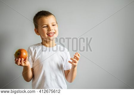 Boy Without Milk Upper Tooth In White T-shirt Smiling On The Gray Background.