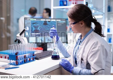 Scientist Looking At Sample Into Micropipette For Biology Hospital Test. Biology Doctor Discovery Sc