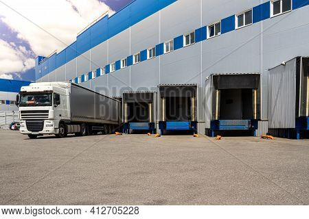 Truck While Loading In A Big Distribution Warehouse With Gates For For Loading Goods And Trucks