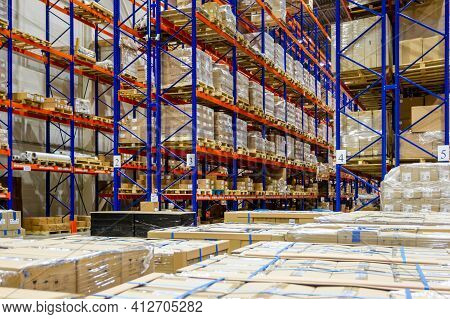 Interior Of A Modern Warehouse Storage Of Retail Shop With Pallet Truck Near Shelves