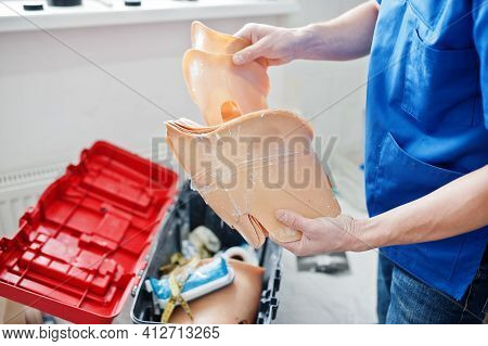 Prosthetist Man Making Prosthetic Leg While Working In Laboratory.