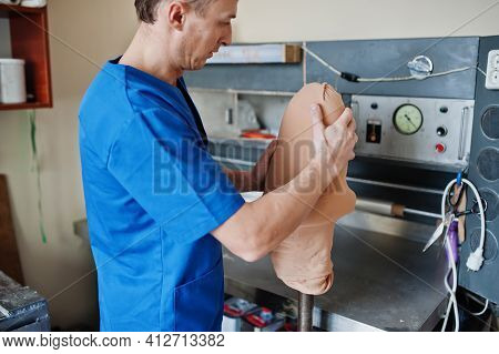 Prosthetist Man Making Prosthetic Leg While Working In Laboratory.