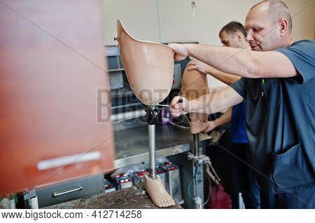 Two Prosthetist Man Workers Making Prosthetic Leg While Working In Laboratory.