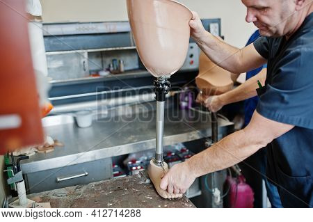 Two Prosthetist Man Workers Making Prosthetic Leg While Working In Laboratory.