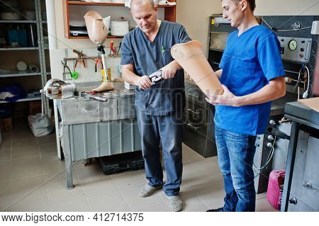 Two Prosthetist Man Workers Making Prosthetic Leg While Working In Laboratory.