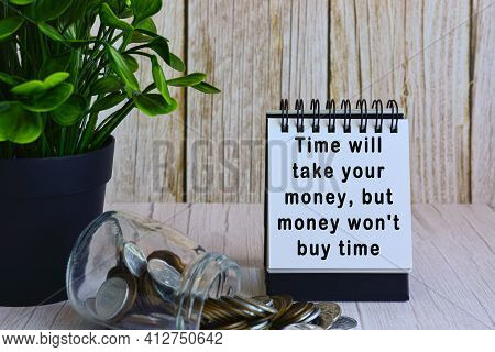 Motivational Quote On Paper Stand And Blurred Glass Jars With Multicurrency Coins
