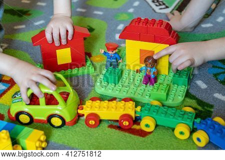 Naples, Italy, March 2020: Close-up Of Child's Hands Playing With Colorful Plastic Bricks On A Color