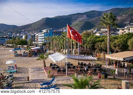 Alanya , Turkey- October 20, 2020:The flag of Turkey flutters on Kleopatra's beach  on suny day Alanya. Turkey.