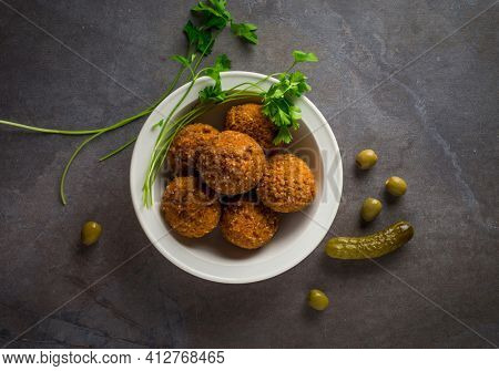 Bowl full of fried Falafel with olives and pickle. Stock image. Authentic traditional middle eastern street food- falafil.