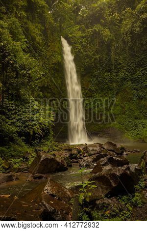 Waterfall Landscape. Beautiful Hidden Waterfall In Tropical Rainforest. Foreground With Big Stones. 